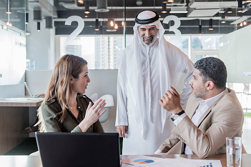 Business professionals discussing opportunities at IFZA Free Zone in a modern office setting.